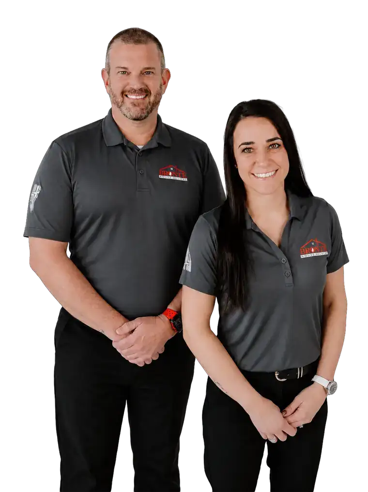 Jeremy Prunty and Cristine, Omaha home buyers with Bronte House Buyer, standing in gray polos