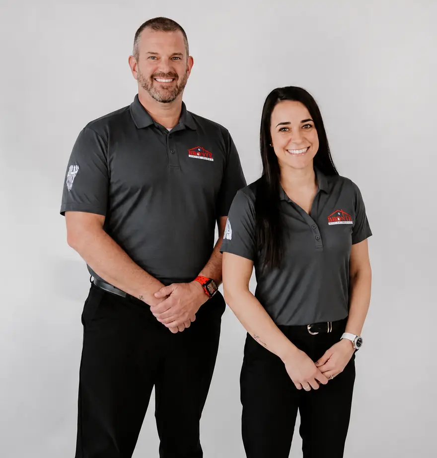 Jeremy and Cristine of Bronte House Buyer standing together and smiling in gray company polos